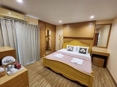 a bedroom with a large bed and a mirror at Alaita Hostel Patong in Patong Beach