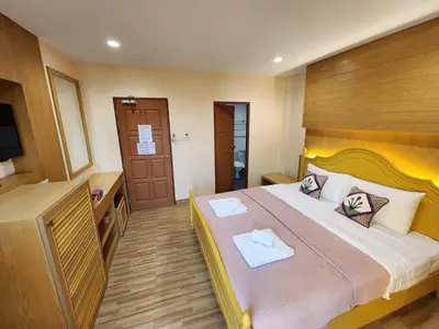 a hotel room with a large bed and a television at Alaita Hostel Patong in Patong Beach