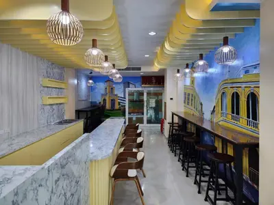 a restaurant with a bar with chairs and lights at Alaita Hostel Patong in Patong Beach