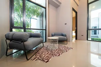 a living room with two chairs and a rug at Serene Wallaya Villa Harmony in Ban Pak Lak