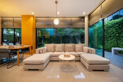 a living room with a couch and a table at Serene Wallaya Villa Harmony in Ban Pak Lak