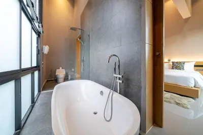 a bath tub in a bathroom with a bedroom at Serene Wallaya Villa Harmony in Ban Pak Lak