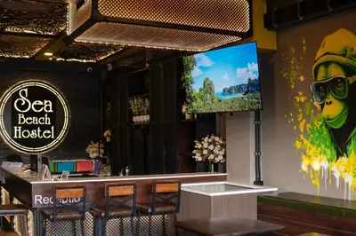 a bar in a restaurant with a tv on the wall at Sea Beach Hostel & Club Beachfront 18-39 years only in Ao Nang Beach