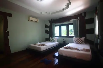 a room with two beds and a window at Baan Pongam Resort in Ao Nang Beach