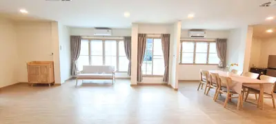 a dining room with a table and chairs and windows at 48 House in Patong Beach