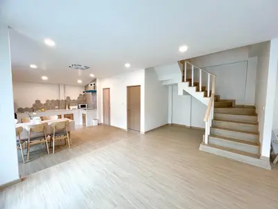 a living room with a dining table and a staircase at 48 House in Patong Beach