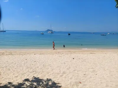 a person walking on a beach with the ocean at Heimat Garden - Your Home in Koh Yao Yai in Ban Lo Pa Ret