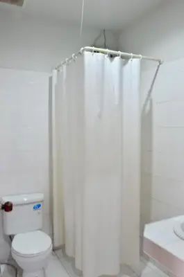 a bathroom with a toilet and a shower curtain at Heimat Garden - Your Home in Koh Yao Yai in Ban Lo Pa Ret