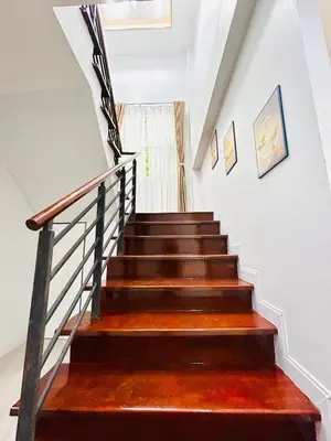a staircase with wooden floors and white walls at Vibe Phuket Private Rooms in Shared Villa Some Shared Bathrooms in Phuket Town