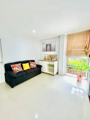 a living room with a black couch and a window at Vibe Phuket Private Rooms in Shared Villa Some Shared Bathrooms in Phuket Town