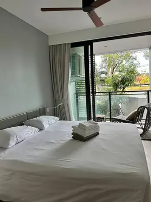 a bedroom with a white bed with a large window at Квартира Cassia Residences Lake View in Bang Tao Beach