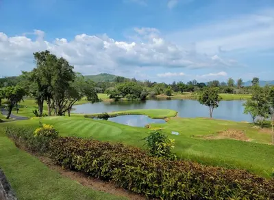 a golf course with a lake in the background at Room61-รูม61 in Phuket Town