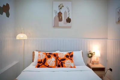 a bedroom with a bed with orange and white pillows at Room61-รูม61 in Phuket Town