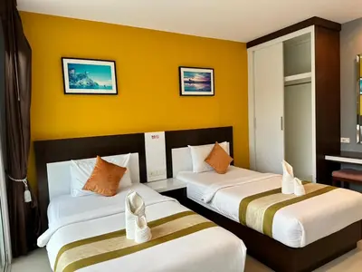 two beds in a hotel room with yellow walls at Gypsy Sea View Resort- Phi Phi Island in Phi Phi Don