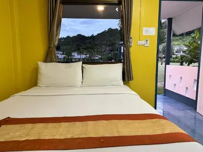a bed in a yellow room with a window at Gypsy Sea View Resort- Phi Phi Island in Phi Phi Don