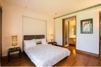 a bedroom with a bed and a lamp on a wooden floor at Pearl of Naithon 3 bedrooms in Nai Thon Beach