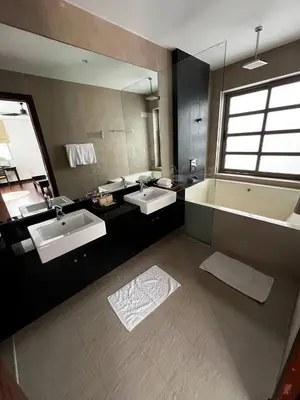 a bathroom with two sinks and a large mirror at The Residence Resort in Phuket Town