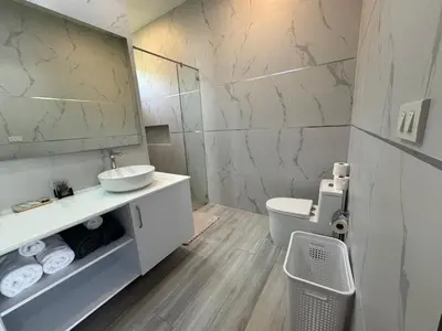 a bathroom with a sink and a toilet and a mirror at Sweet Luxury by G Estate Phuket in Ban Saiyuan (1)