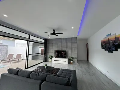 a living room with a couch and a ceiling fan at Sweet Luxury by G Estate Phuket in Ban Saiyuan (1)