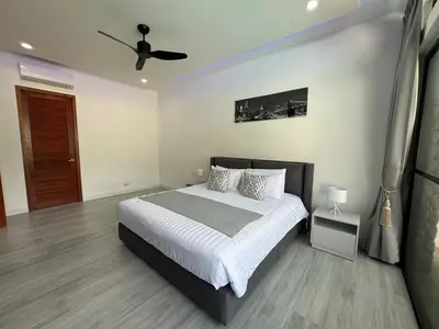 a bedroom with a bed and a ceiling fan at Sweet Luxury by G Estate Phuket in Ban Saiyuan (1)