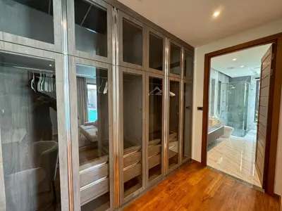 a room with glass doors and a room with wooden floors at Luxury Breeze Villa with private pool & maid in Bang Tao Beach