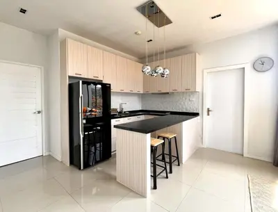 a kitchen with a black counter and wooden cabinets at Stylish penthouse with panoramic views at Icon Park in Kamala Beach