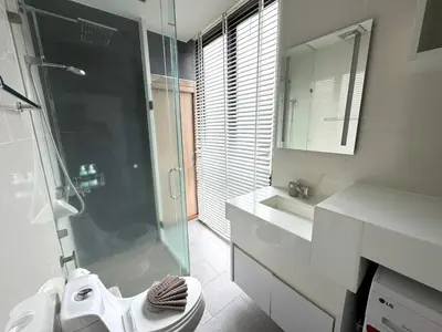 a bathroom with a shower and a toilet and a sink at Stylish penthouse with panoramic views at Icon Park in Kamala Beach