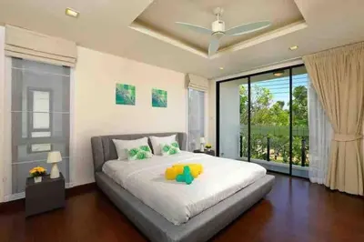 a bedroom with a large white bed and a large window at Big Lucky home in Laguna park in Bang Tao Beach