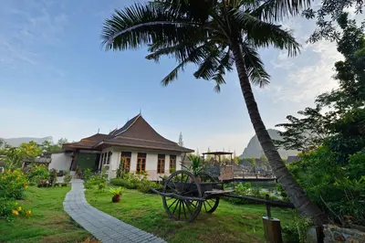 a house with a palm tree in front of it at Poonsiri Resort Aonang-SHA Extra Plus in Ao Nang Beach