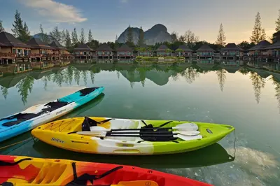 three boats sitting in the water in front of buildings at Poonsiri Resort Aonang-SHA Extra Plus in Ao Nang Beach