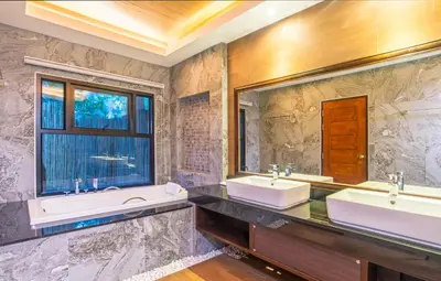 a bathroom with two sinks and a window at Poonsiri Resort Aonang-SHA Extra Plus in Ao Nang Beach