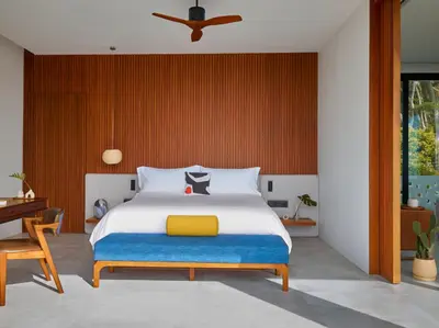 a bedroom with a bed with a yellow and blue blanket at Casa Alma by Elite Havens in Nai Harn Beach