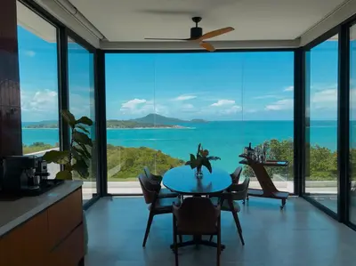 a kitchen with a table with a view of the ocean at Casa Alma by Elite Havens in Nai Harn Beach