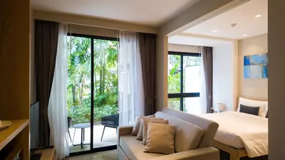 a bedroom with a bed and a couch and a window at Diamond Apartment with Terrace near Bang Tao Beach in Bang Tao Beach