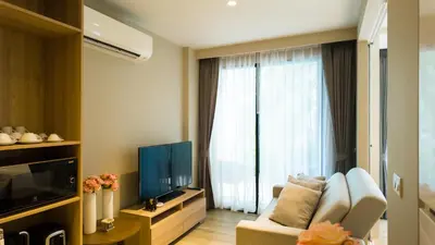 a living room with a couch and a large window at Diamond Apartment with Terrace near Bang Tao Beach in Bang Tao Beach