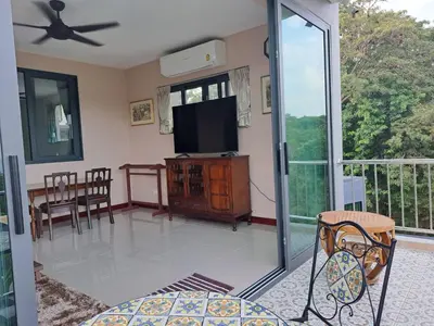a living room with a television and a table and chairs at Seaview Eagles Nest Apartments in Rawai Beach
