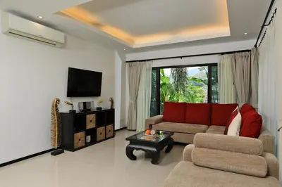 a living room with a couch and a tv at Thaimond Residence by TropicLook Walkable distance to Naiharn beach in Nai Harn Beach