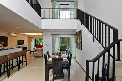 a staircase in a house with a dining room and a kitchen at Thaimond Residence by TropicLook Walkable distance to Naiharn beach in Nai Harn Beach