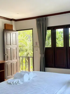 a bedroom with a bed and a large window at Botanic Boutique Hotel Surin Beach in Bang Tao Beach