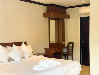 a bedroom with a bed with white towels on it at Botanic Boutique Hotel Surin Beach in Bang Tao Beach