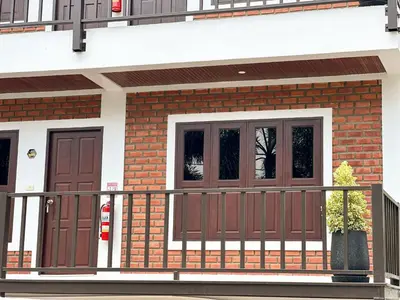 a house with brown doors and a fence at Botanic Boutique Hotel Surin Beach in Bang Tao Beach