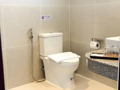 a bathroom with a toilet and a sink at Botanic Boutique Hotel Surin Beach in Bang Tao Beach
