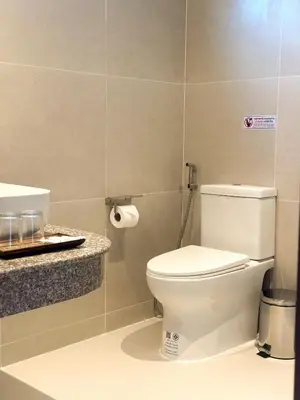 a bathroom with a white toilet and a sink at Botanic Boutique Hotel Surin Beach in Bang Tao Beach
