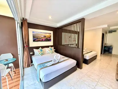 a bedroom with two beds and a balcony at Thai Classic House in Patong Beach