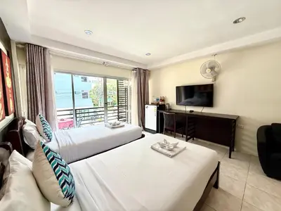 a hotel room with two beds and a television at Thai Classic House in Patong Beach