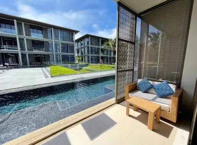 a balcony with a couch and a swimming pool at Baan Mai Khao 3 Br in Phuket Town
