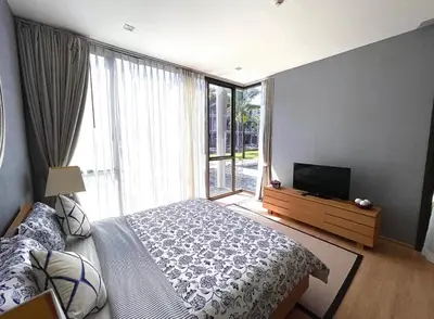 a bedroom with a bed and a large window at Baan Mai Khao 3 Br in Phuket Town
