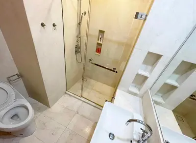 a bathroom with a shower and a toilet and a sink at Baan Mai Khao 3 Br in Phuket Town