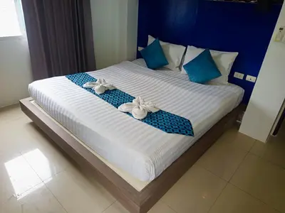 a bed with two pairs of shoes on it at Hotel The Journey Patong New in Patong Beach