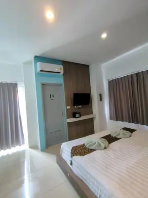 a hotel room with two beds and a television at Hotel The Journey Patong New in Patong Beach